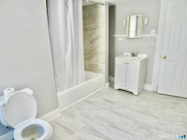 a bathroom with a sink toilet and shower