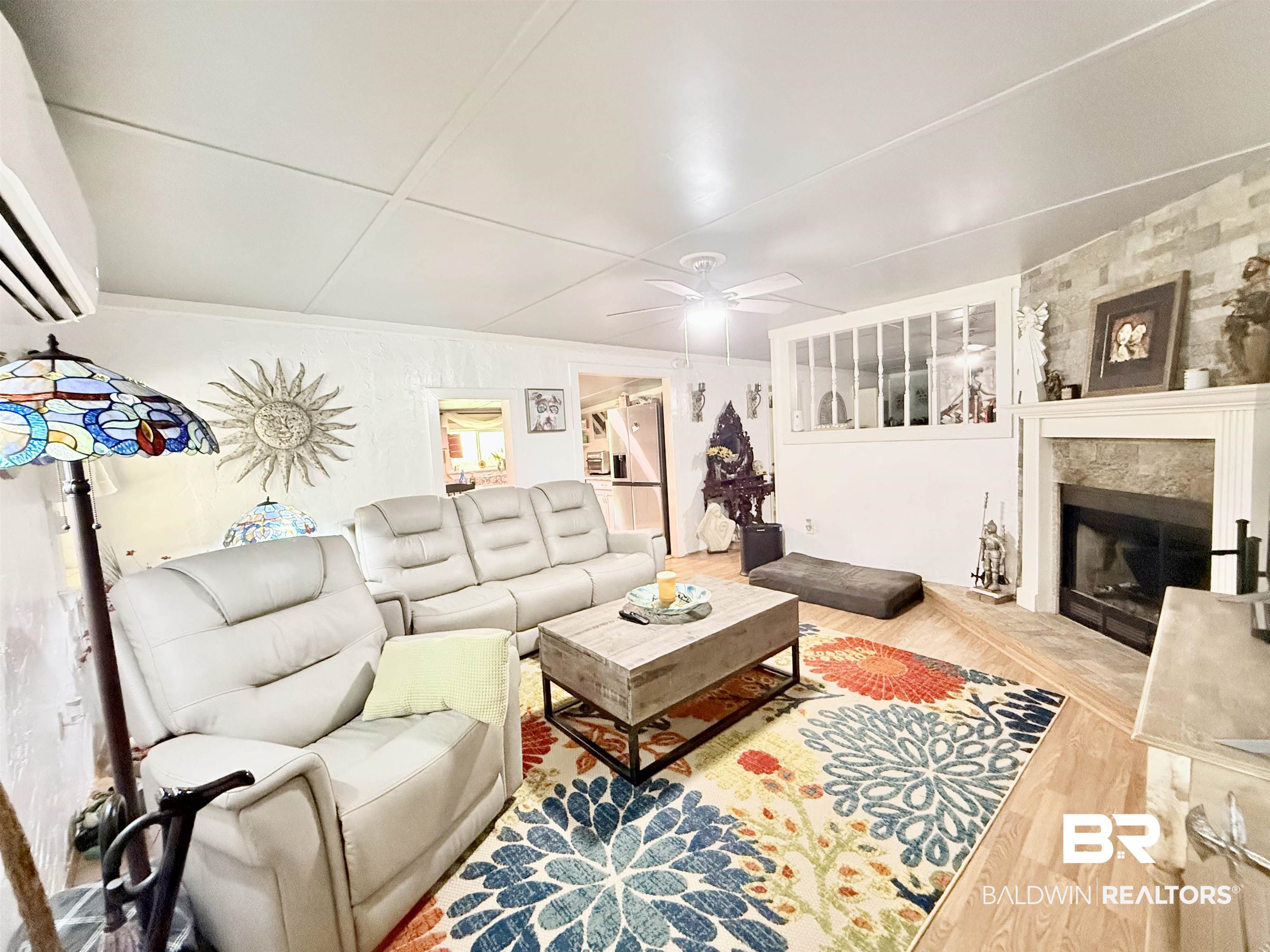 21305 River Road Robertsdale, AL 36567 - Photo 6 of 50 Living area with wood finished floors, an AC wall unit, a tile fireplace, and ceiling fan