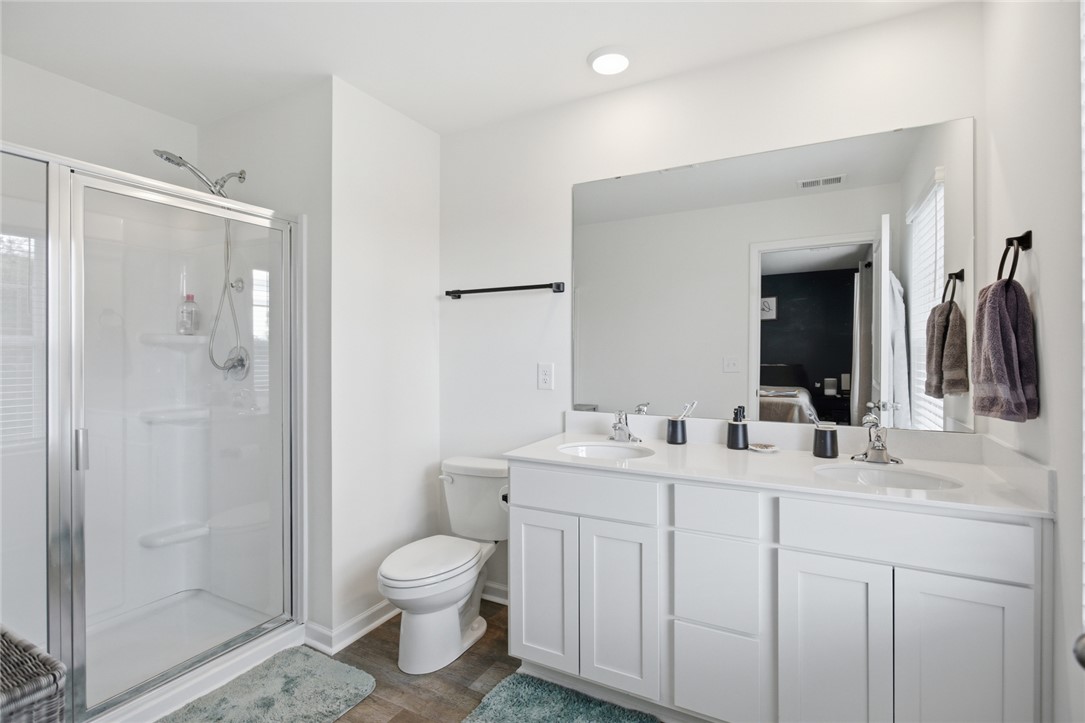1055 South Depot Street Seneca, SC 29678 - Photo 30 of 43 This primary bathroom features a dual vanity, sleek shower, and modern fixtures, creating a refreshed environment.