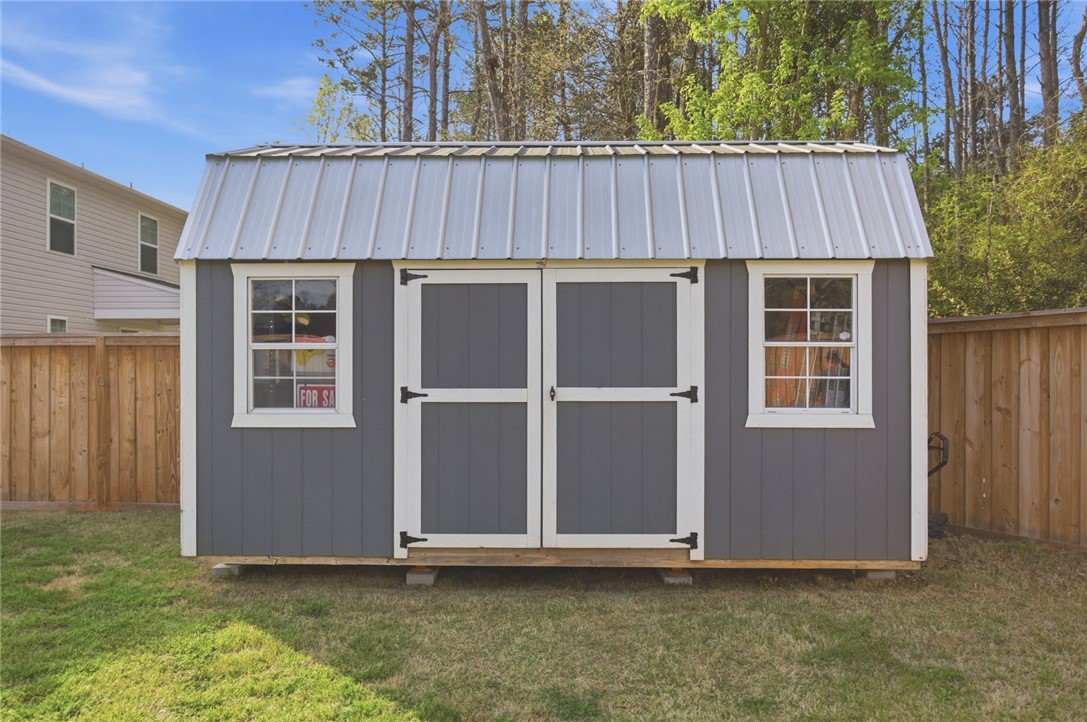 1055 South Depot Street Seneca, SC 29678 - Photo 37 of 43 This charming backyard storage solution offers practicality and rustic appeal.