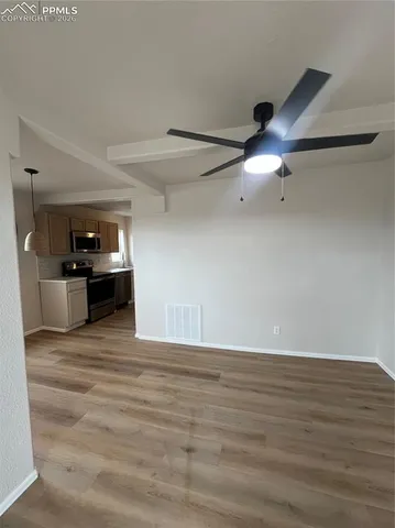 a view of an empty room with wooden floor