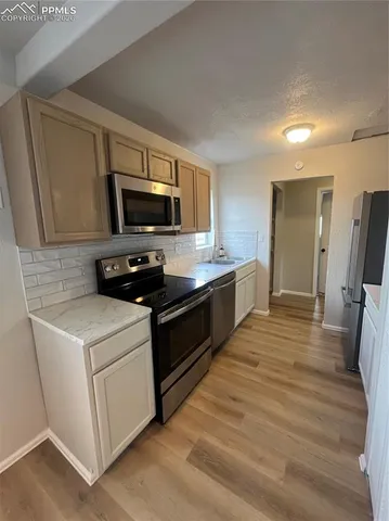 a kitchen with stainless steel appliances a stove microwave and refrigerator