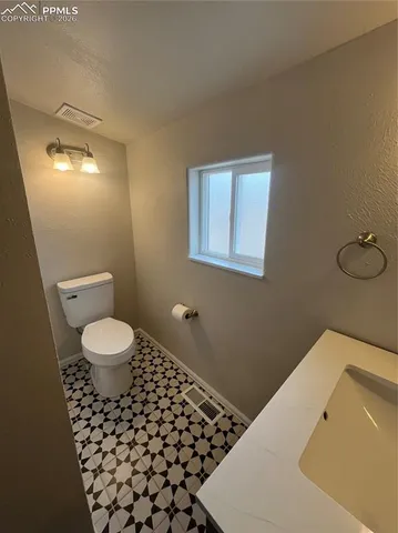 a bathroom with a toilet a sink and mirror