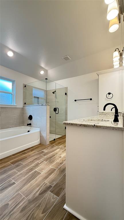 704 Ransom Way Greenville, TX 75402 - Photo 8 of 23 Full bath with vanity, a shower stall, wood tiled floors, a bath, and recessed lighting
