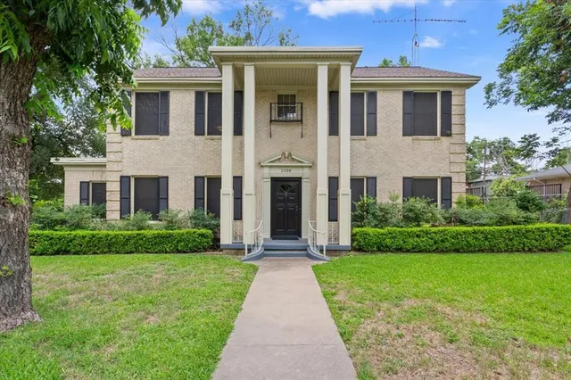 a front view of a house with yard and green space