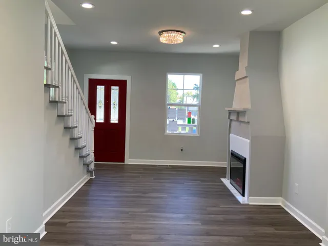 an empty room with wooden floor and a window