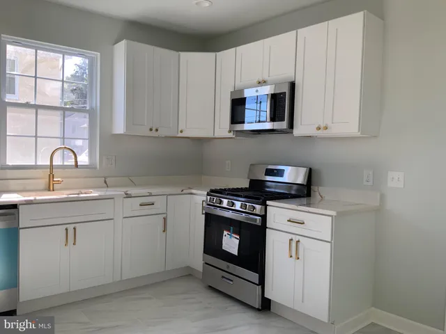 a kitchen with white cabinets and white appliances