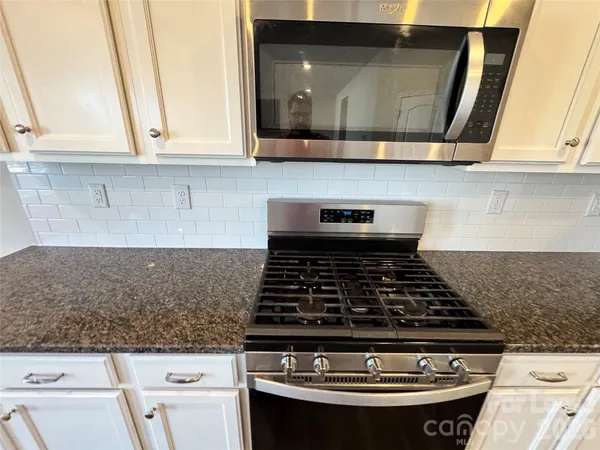 an empty room with wooden floor and fireplace