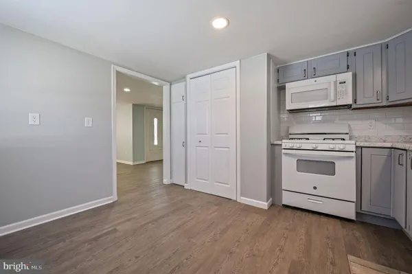 a view of a kitchen with wooden floor and electronic appliances