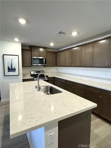 a kitchen with stainless steel appliances granite countertop a sink and a stove