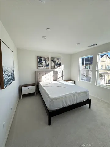 a bed sitting in a bedroom next to a window