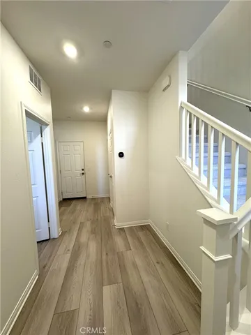 a view of a hallway with wooden floor and staircase