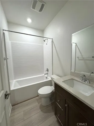 a bathroom with a bathtub shower sink mirror vanity and toilet
