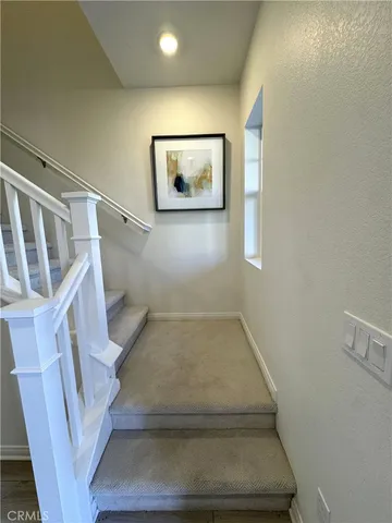 a view of staircase with white walls and a window