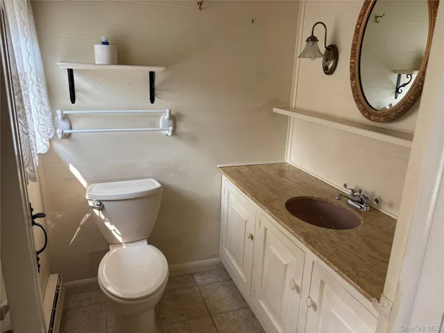 a bathroom with a granite countertop toilet sink and mirror