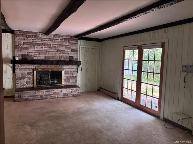 a view of an empty room with a fireplace and a window