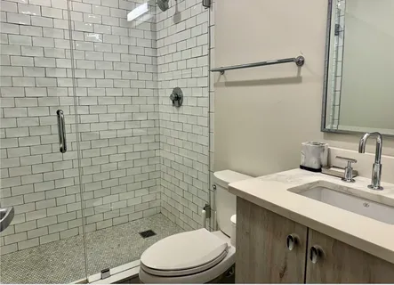 a bathroom with a sink a toilet and shower