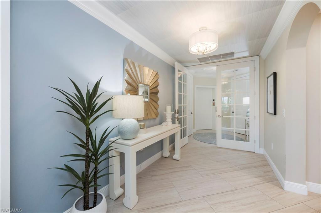 Foyer entrance featuring french doors, crown molding, and arched walkways