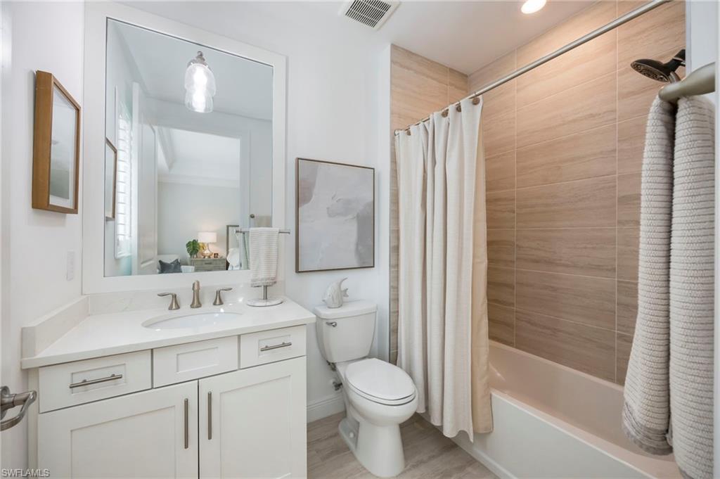16351 Viansa Way, Unit 202 Naples, FL 34110 - Photo 18 of 35 Full bathroom with vanity, shower / bath combination with curtain, and light wood finished floors
