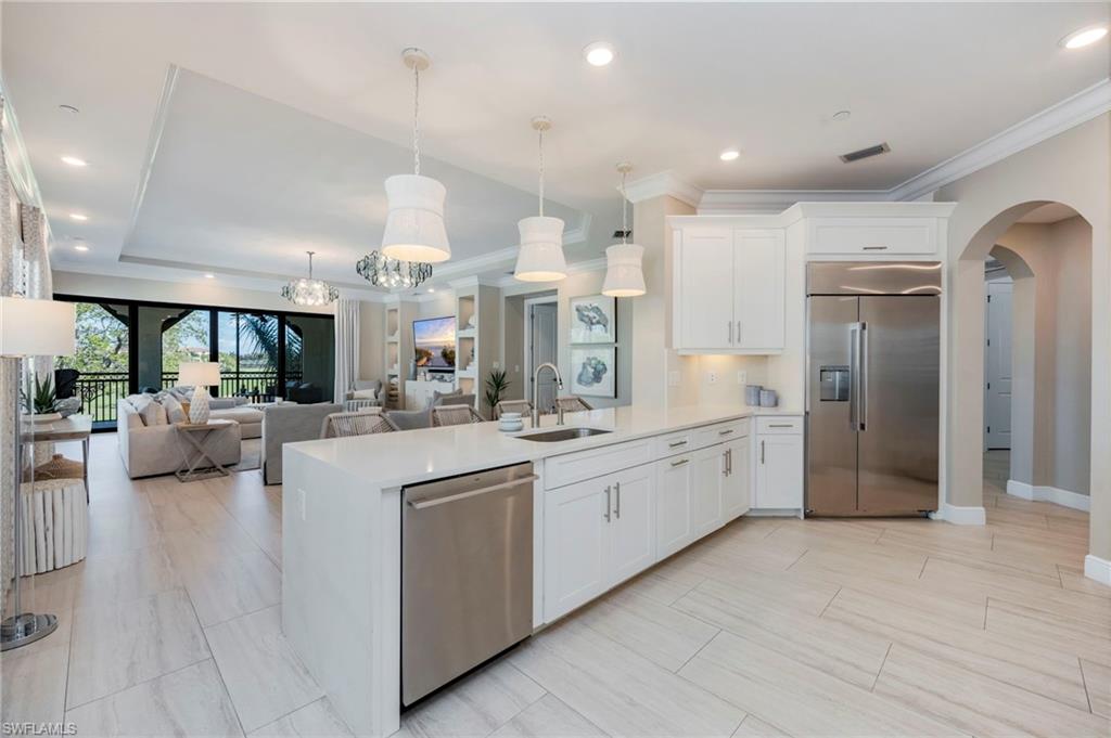 16351 Viansa Way, Unit 202 Naples, FL 34110 - Photo 35 of 35 Kitchen featuring arched walkways, stainless steel appliances, white cabinets, open floor plan, and ornamental molding