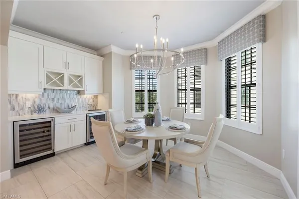 a large white kitchen with stainless steel appliances kitchen island granite countertop a large kitchen island a stove and a sink