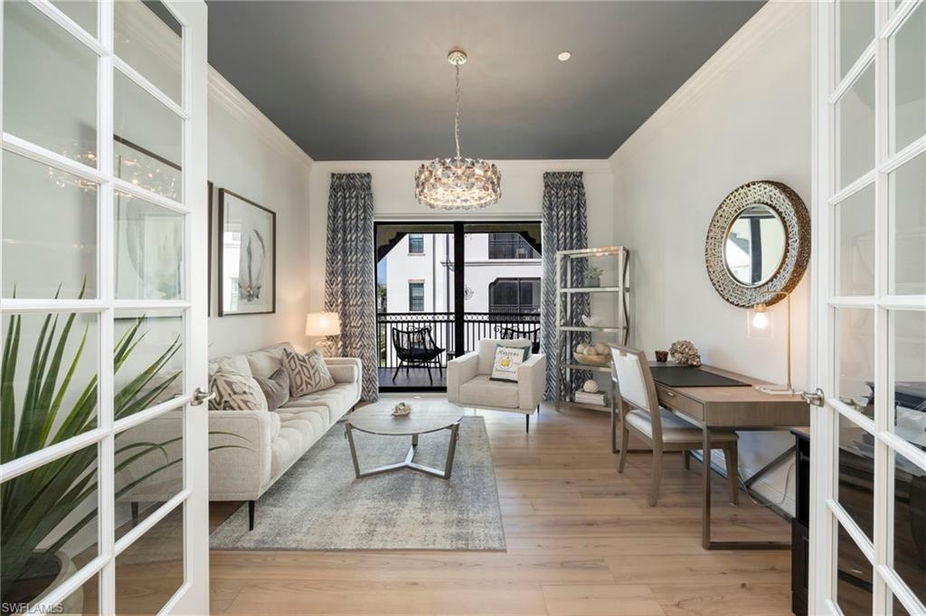 16351 Viansa Way, Unit 202 Naples, FL 34110 - Photo 9 of 35 Living area with crown molding, light wood-style floors, a chandelier, and french doors
