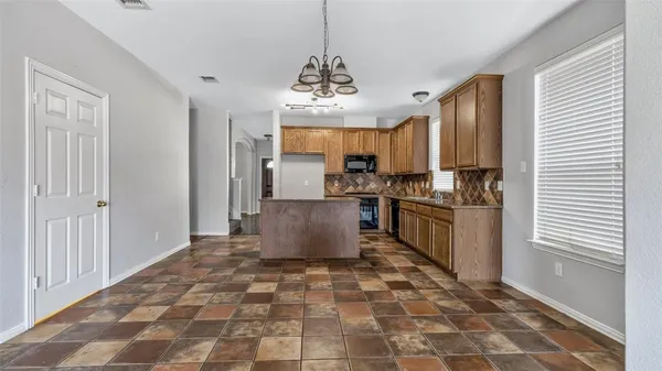 a kitchen with kitchen island granite countertop a sink appliances cabinets and furniture