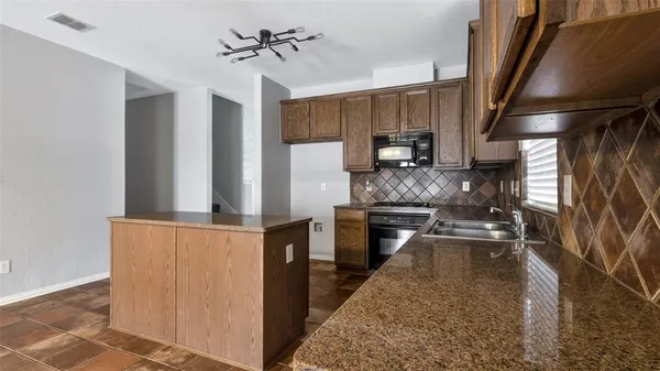 a kitchen with stainless steel appliances granite countertop a refrigerator a sink dishwasher a stove with wooden cabinets and floor