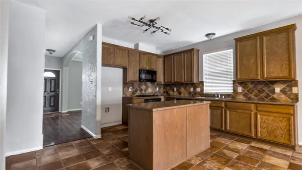 a kitchen with granite countertop cabinets and black appliances