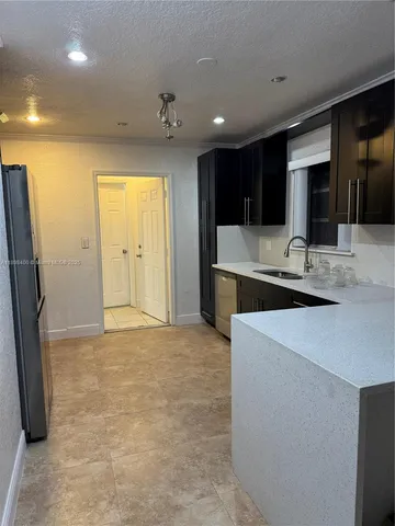 a kitchen with kitchen island a sink stainless steel appliances and cabinets