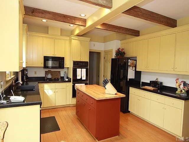 5000 Salem Ridge Road Holly Springs, NC 27540 - Photo 4 of 11 Kitchen has 2 pantries, butcher block center island, granite counter tops, microwave, double oven, gas cooktop, newer disposal & recessed lighting Kitchen
