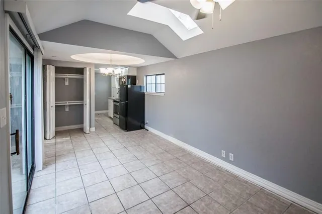 a view of an empty room and kitchen view