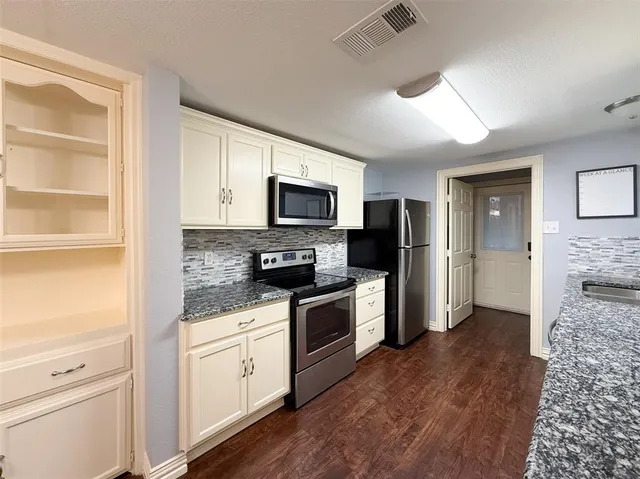 a kitchen with a refrigerator stove and microwave