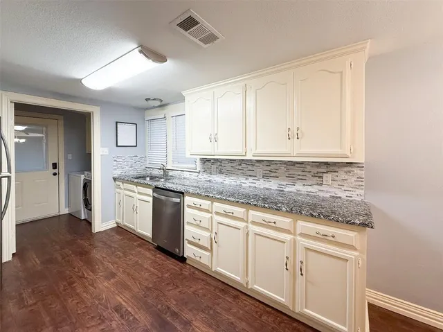 a kitchen with granite countertop white cabinets and white appliances