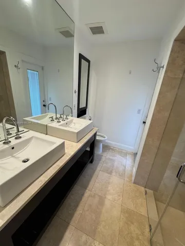 a bathroom with a double vanity sink and a mirror