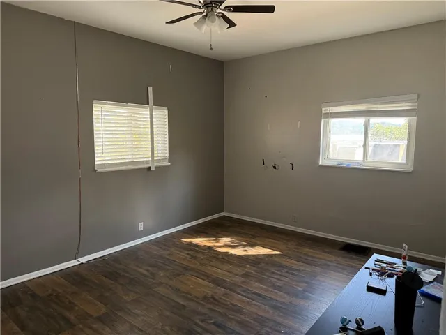 a bedroom with a bed and potted plants next to a large window