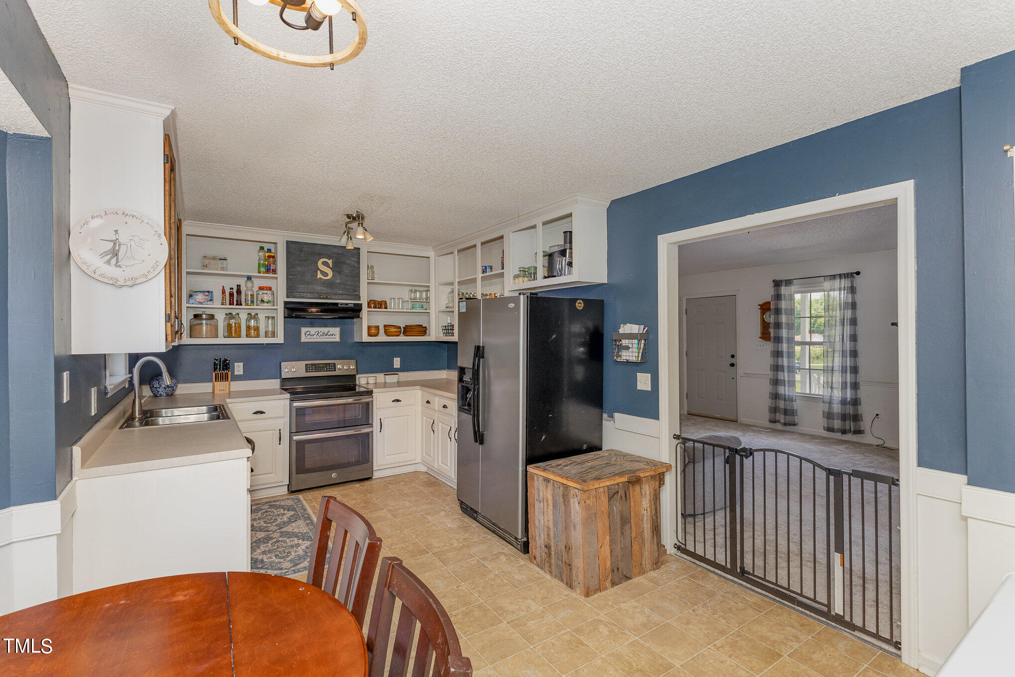 112 Forest Ridge Drive Willow Spring, NC 27592 - Photo 8 of 21 a kitchen with a refrigerator a stove top oven a sink dishwasher and white cabinets with wooden floor