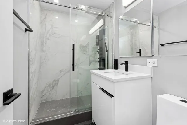 a bathroom with a sink a toilet and shower