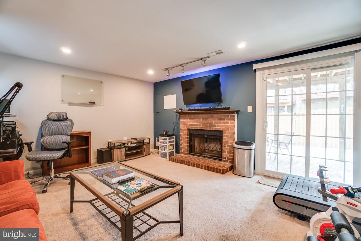6067 Knights Ridge Way Alexandria, VA 22310 - Photo 29 of 39 a living room with furniture a flat screen tv and a fireplace
