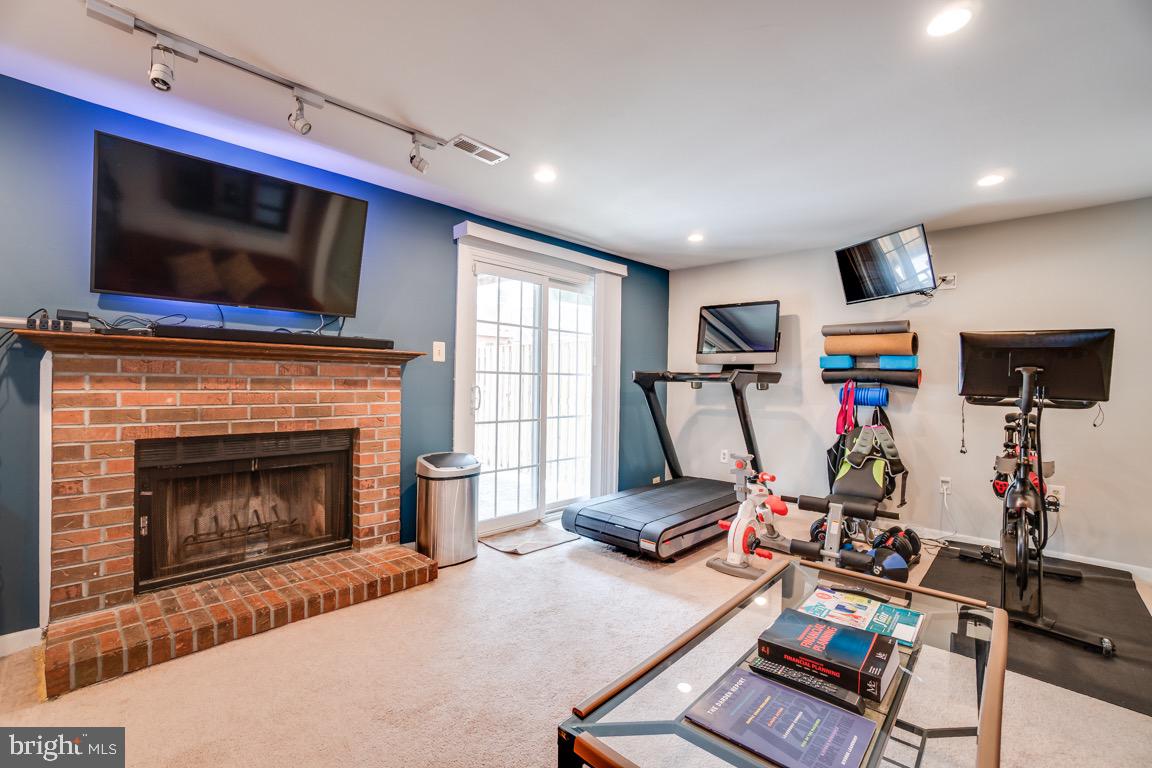 6067 Knights Ridge Way Alexandria, VA 22310 - Photo 31 of 39 a living room with furniture a flat screen tv and a fireplace