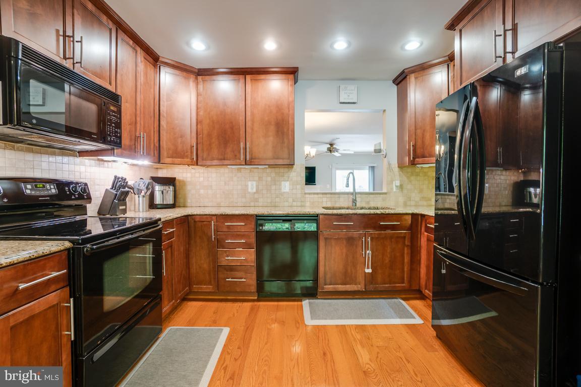 6067 Knights Ridge Way Alexandria, VA 22310 - Photo 8 of 39 a kitchen with stainless steel appliances granite countertop a refrigerator a stove a sink and a microwave