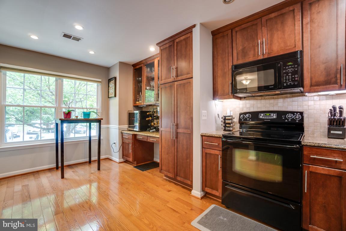 6067 Knights Ridge Way Alexandria, VA 22310 - Photo 10 of 39 a kitchen with granite countertop a stove top oven microwave and refrigerator
