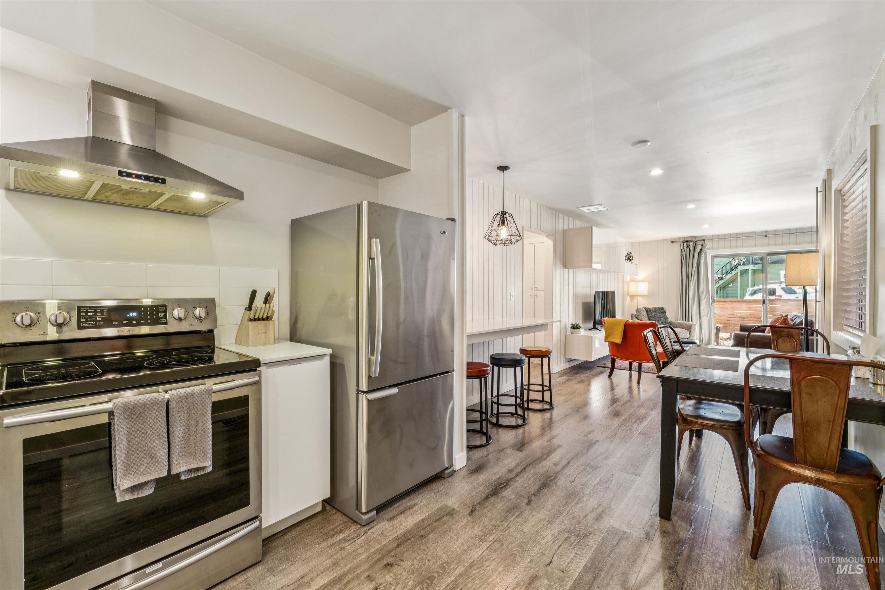 925 North 9th Street, Unit 20 Boise, ID 83702 - Photo 33 of 35 Kitchen with stainless steel appliances, ventilation hood, light wood finished floors, open floor plan, and white cabinetry