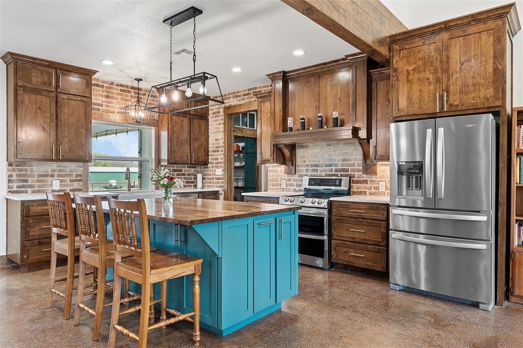 399 Satin Road Chilton, TX 76632 - Photo 5 of 34 a kitchen with stainless steel appliances a refrigerator a stove a sink and chairs