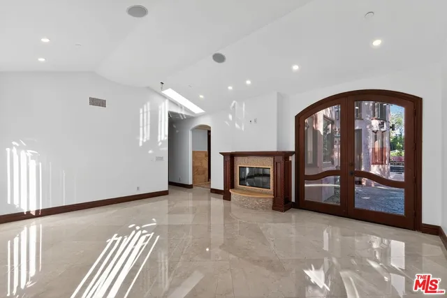 a view of empty room with fireplace and fan