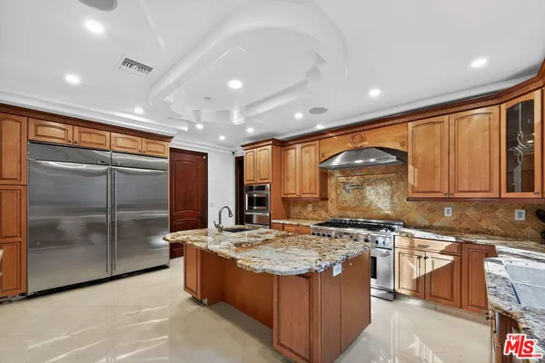 a large kitchen with stainless steel appliances granite countertop a stove sink and cabinets