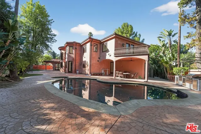 a view of a building with large windows and a small yard