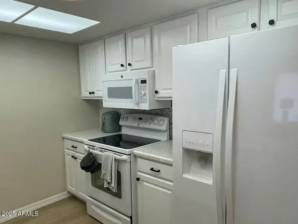 a white refrigerator freezer and a stove sitting inside of a kitchen