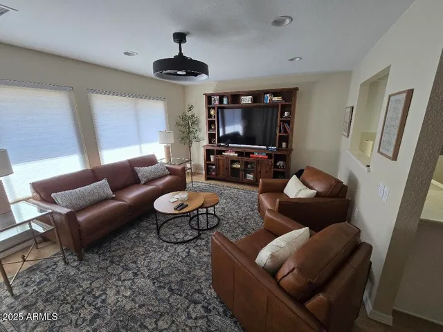 a living room with furniture a flat screen tv and a window