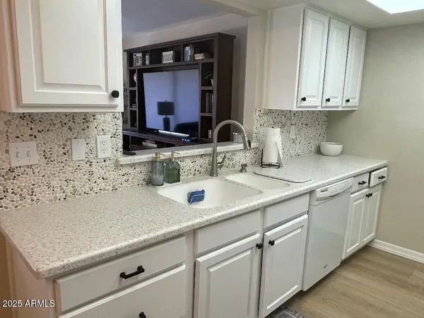 a kitchen with white cabinets and a sink